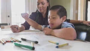 a woman tutoring their special needs foster child with their school assignment